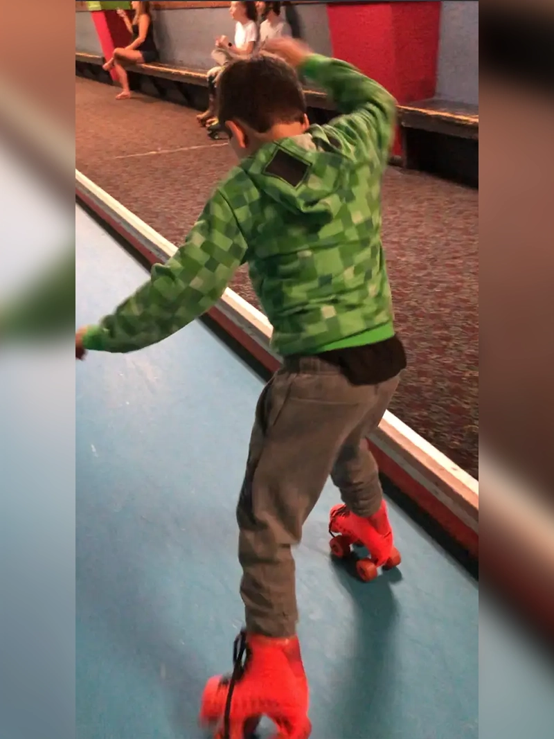 A young boy riding on top of a skateboard.