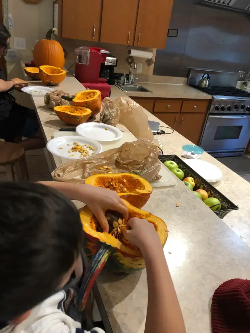 A group of people sitting around a counter with food.