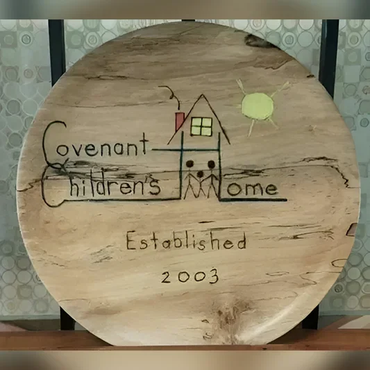 A wooden plate with the name of covenant children 's home on it.